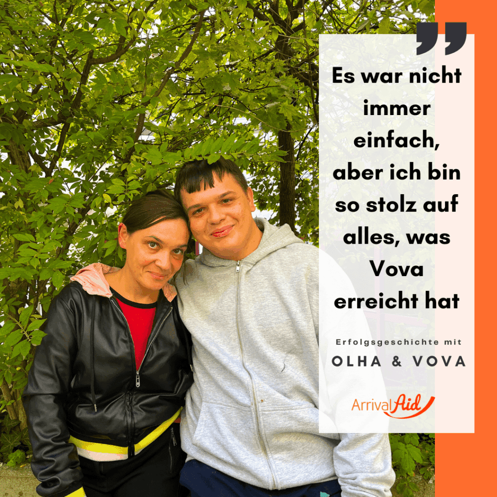 Olga (links) und Vova (rechts) sitzen vor einer grünen Hecke. Beide haben dunkelbraune Haare. Olga trägt eine Lederjacke und darunter ein rotes T-Shirt. Vova trägt einen grauen Kapuzenpullover und hat einen Arm um Olga gelegt. Beide lächeln in die Kamera.